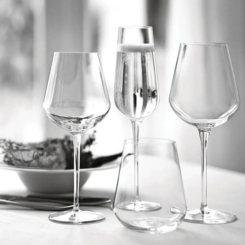 Set of clear wine glasses on a light surface with a blurred background