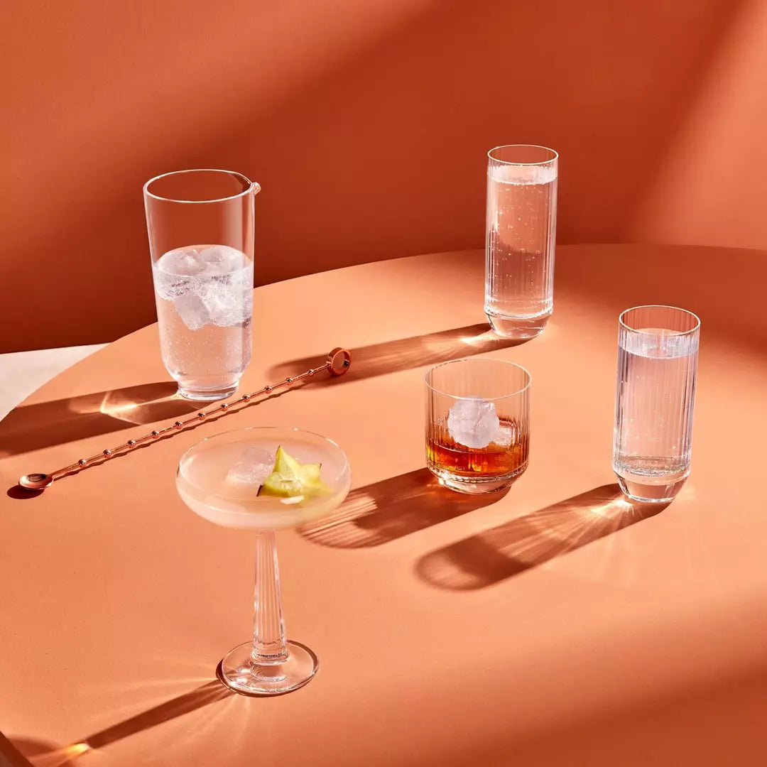Set of cocktail glasses with drinks on a peach-colored surface