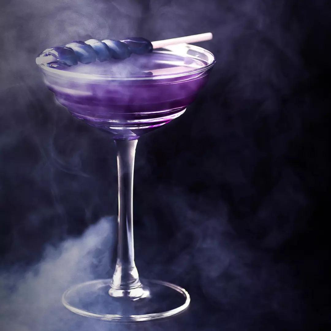 Purple cocktail in a glass with a smoking stick on a dark background