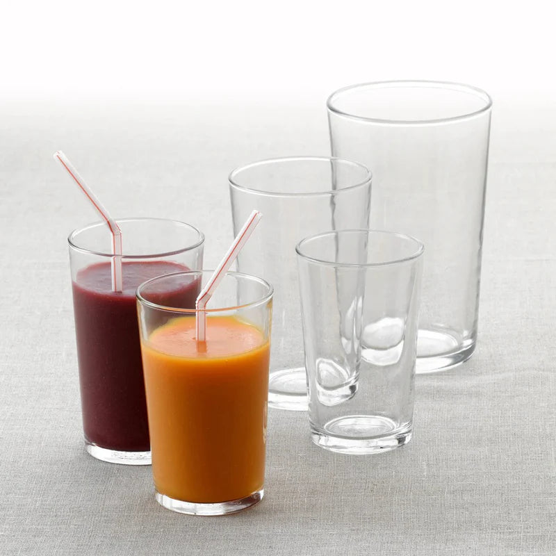 Clear glasses with orange and red drinks on a light gray background