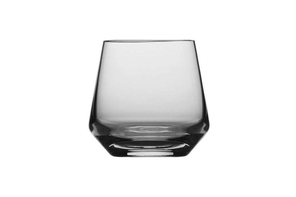 A small clear V shaped whiskey glass on a white background
