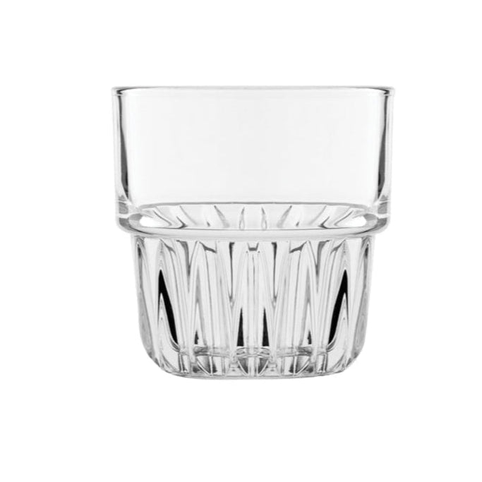 Clear tumbler glass with rippled bottom on white background