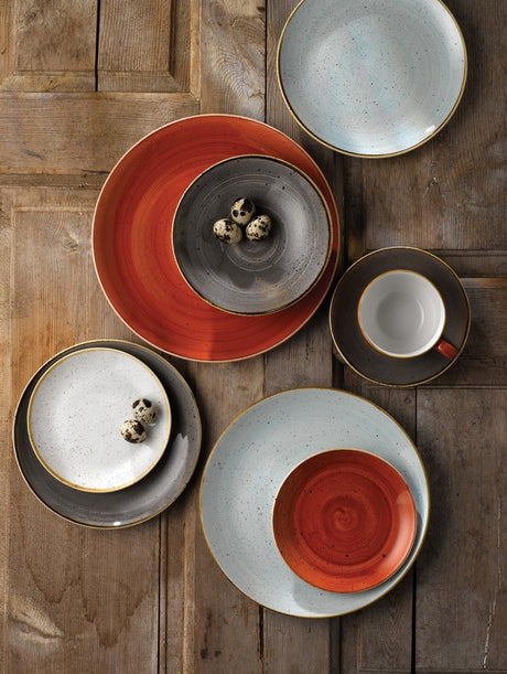 Full range of hand made plates and bowls in different colours on a tsble setting