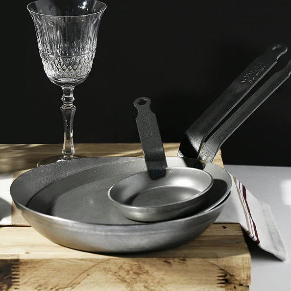 Three iron frypans on a table setting