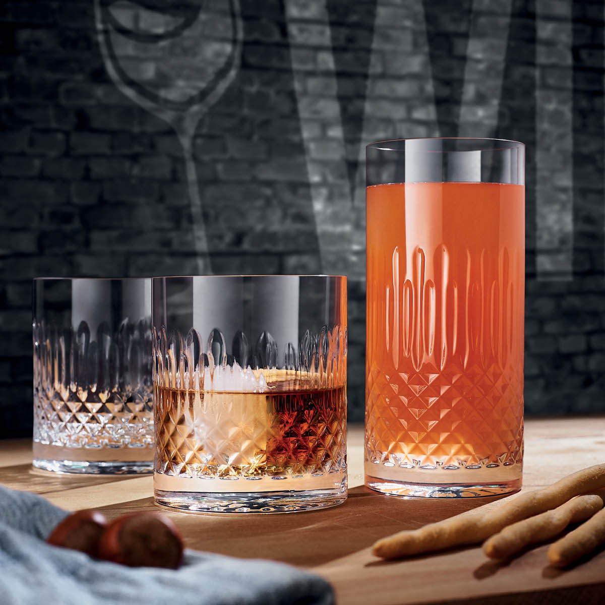 Three Tumblers with liquid on a table setting 