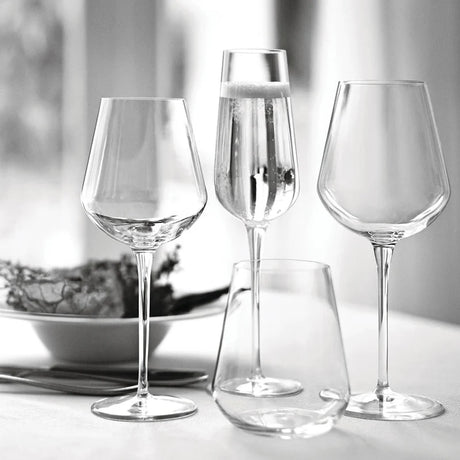 Set of clear wine glasses on a light surface with a blurred background