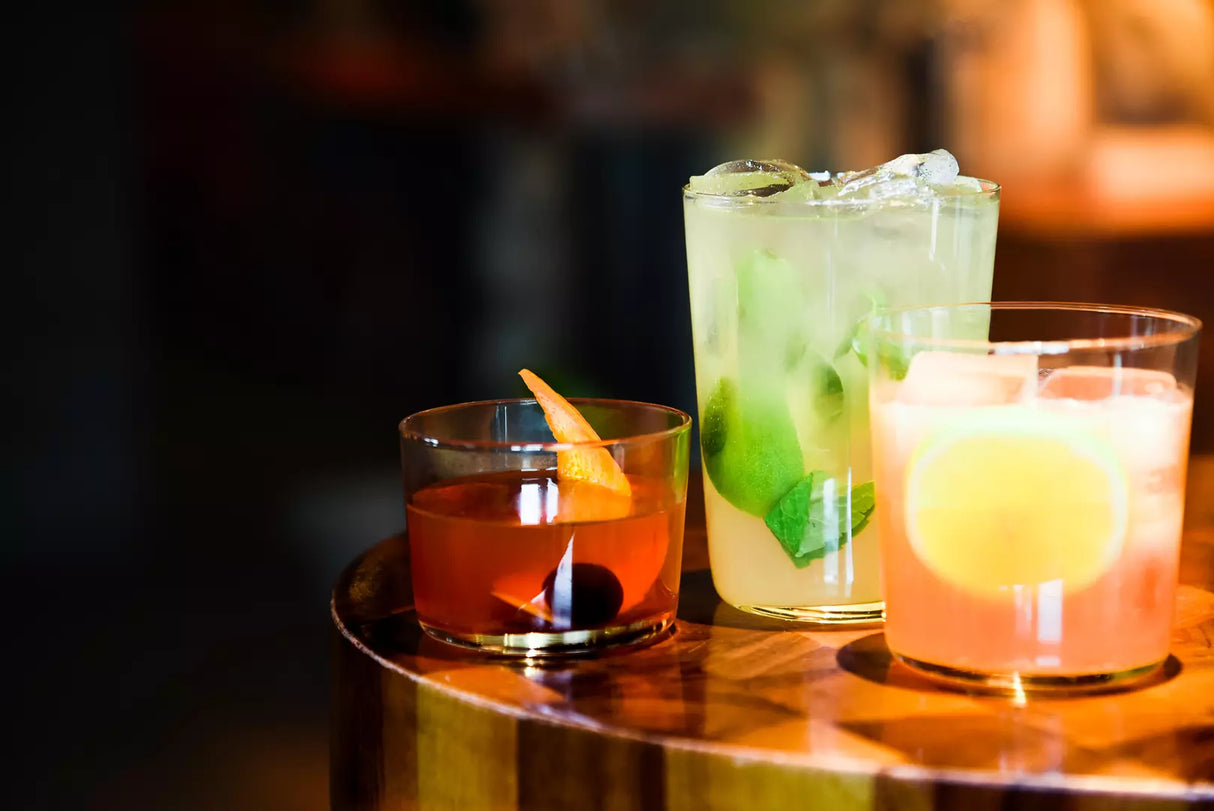 Three glasses with liquid in each in a bar table setting