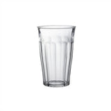 A clear ribbed glass tumbler centered on a plain white background.