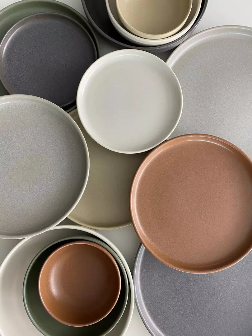 Top-down photo of a range of different coloured plates and bowls. 