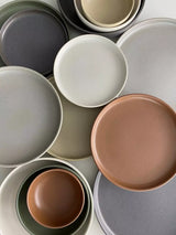 Top-down photo of a range of different coloured plates and bowls. 