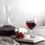Wine decanter and glass with red wine on a marble surface