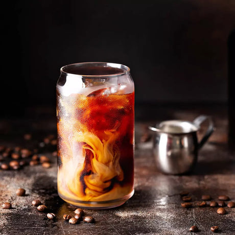 Beer can shaped glass with liquid on a table