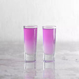2 shot glasses with pink coloured liquid on a marble background
