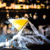 Martini glass with yellow liquid in halloween setting