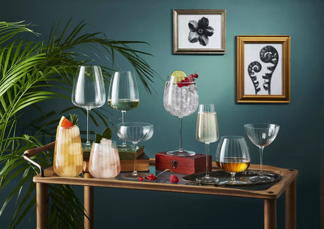 8 different glasses on a table with a blue background