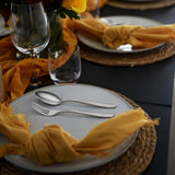 Table setting with spoon and fork on light blue speckled plate
