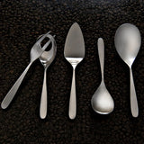 Set of silver utensils including a fork, knife, and spoons on a dark textured surface.