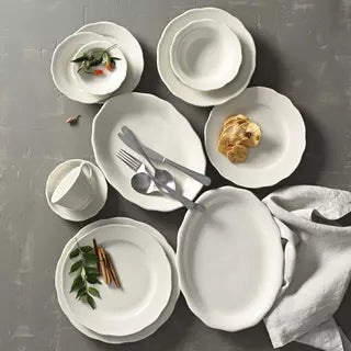 White scalloped crockery items on grey background