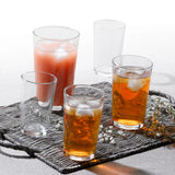 Four glasses with drinks on a textured tray