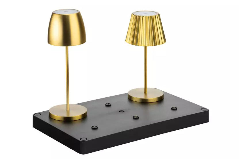A pair of modern table lamps with brushed gold finishes on a black rectangular base, photographed against a solid white background.