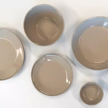 A set of five ceramic plates and bowls in a matching glossy taupe-brown glaze, arranged on a clean white background.