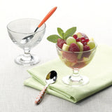 One clear and on dessert cup with fruit salad displayed on a white table setting