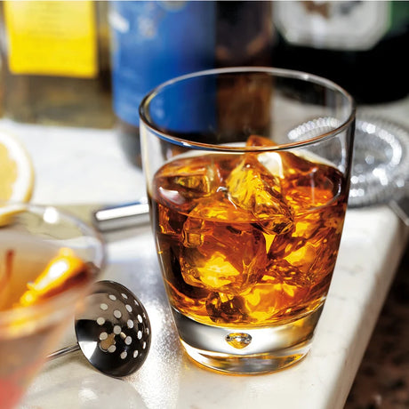 Medium sized tumbler with dimple bottom presented with liquid on a bar setting