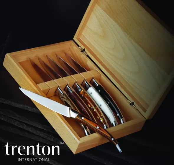 Set of knives in a wooden box with 'trenton international' branding.