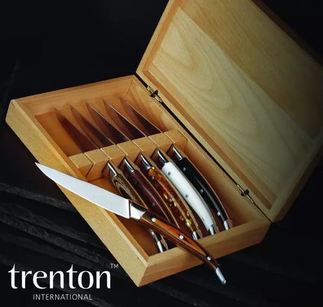 Set of knives in a wooden box with 'trenton international' branding.