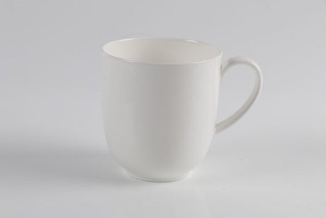 A white traditional large coffee mug on a light grey background