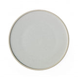 Round white plate with pebble speckle on a white background