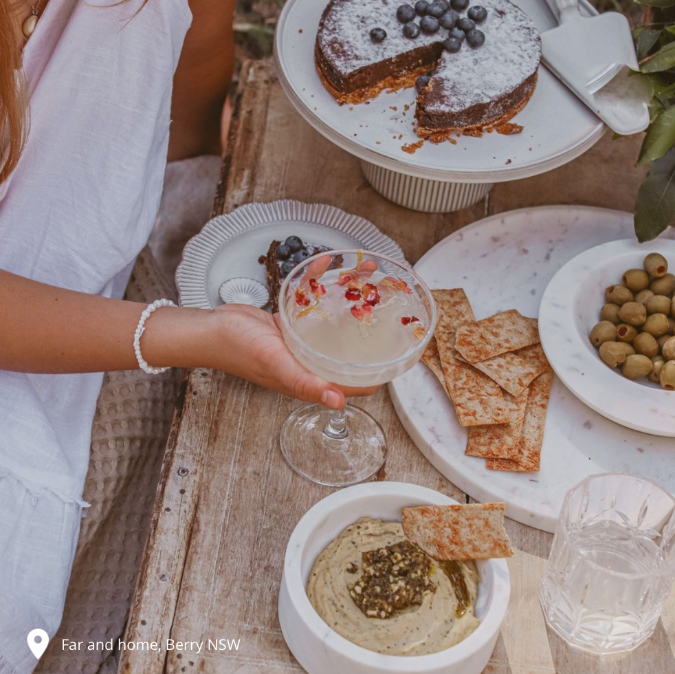 Champagne saucer with plates of food in background