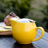 Yellow teapot on garden background