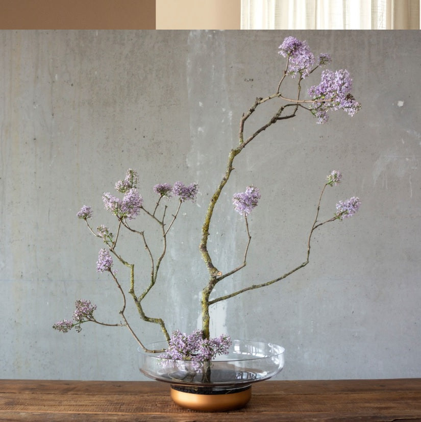 Bowl display with flowers on wooden bench