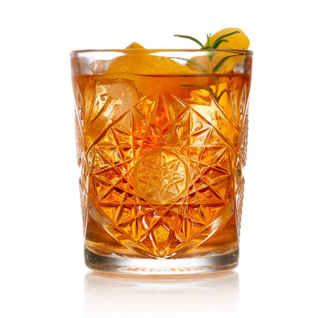 crystal cut glass with liquid and fruit on white background