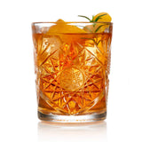 crystal cut glass with liquid and fruit on white background